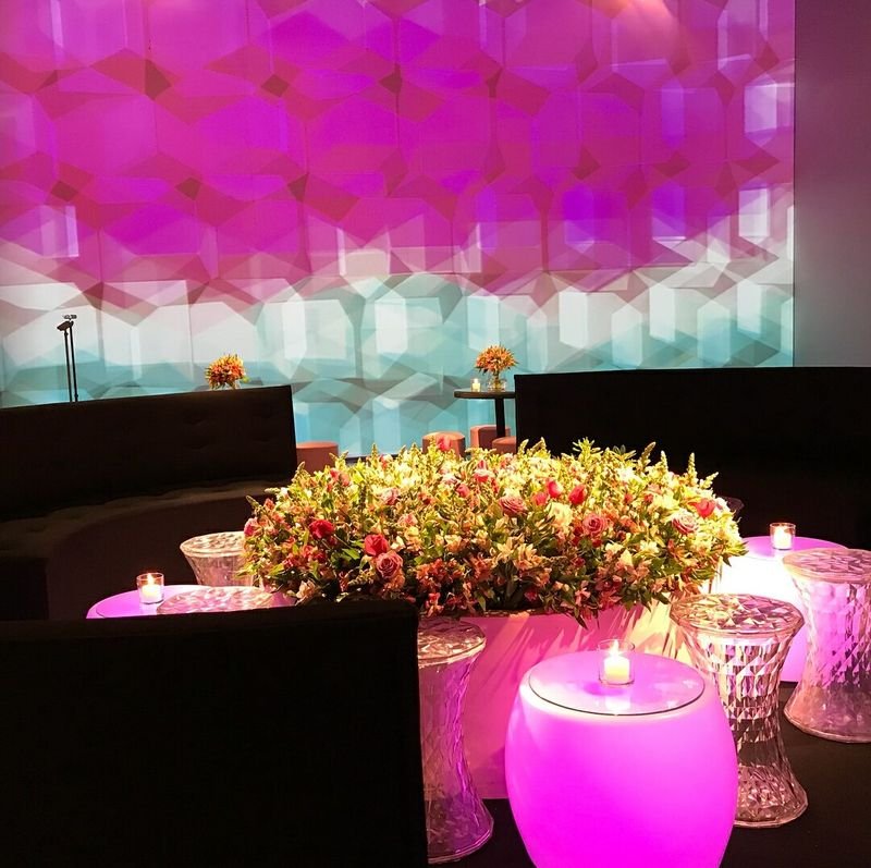 Banqueta LED rosa sob um arranjo de flores
