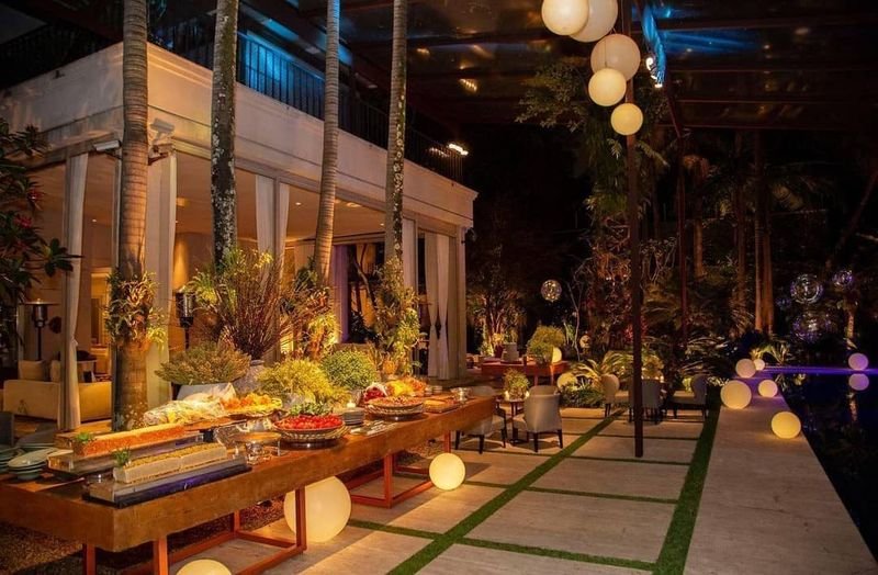 Jardim à noite com esferas LED acesas entre as mesas do buffet