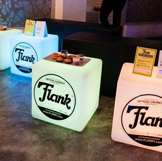 Cubos LED com o logotipo Flank aplicado em adesivo, num balcão de evento