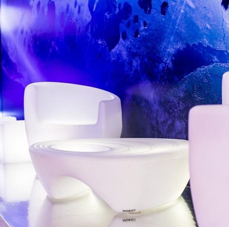 Poltrona LED branca iluminada em azul e roxo